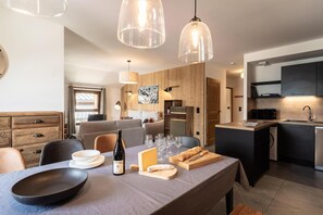 A modern kitchen with a dining area, wooden accents, and pendant lighting. - 50m from ski slopes, 1st floor, view resort, balcony, tv, 86m², Montalbert (La Plagne)
