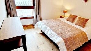 A neatly arranged bedroom with a bed, bedside tables, and a window with curtains. - 50m from ski slopes, 1st floor, view resort, balcony, tv, 86m², Montalbert (La Plagne)