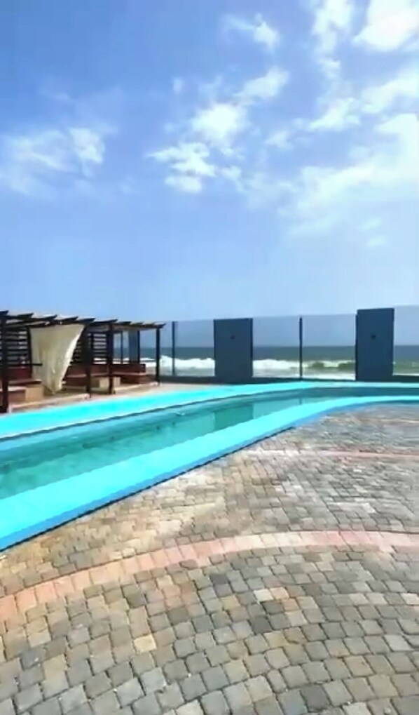 A pool area with a view of the ocean.