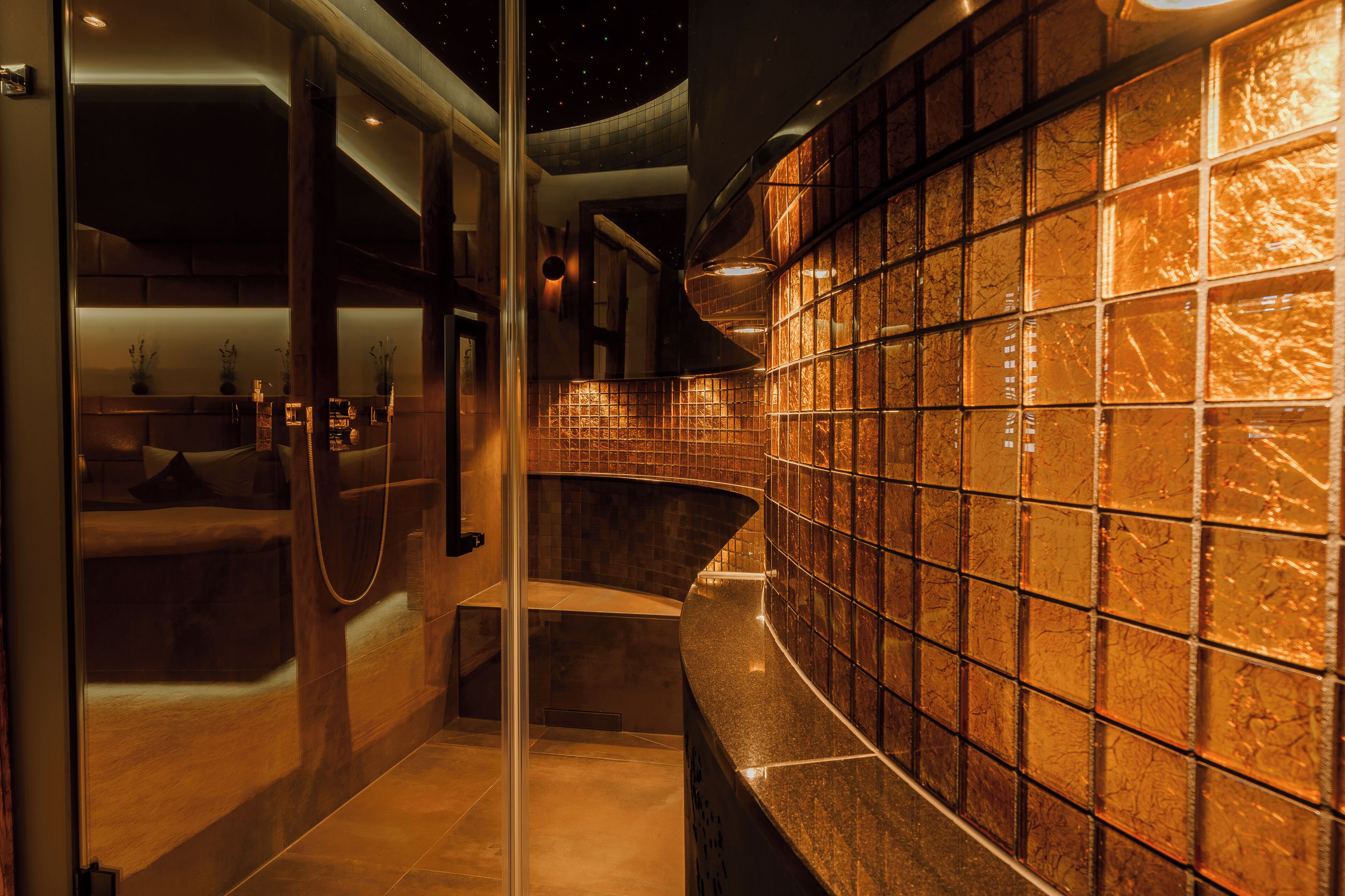 A modern interior with a curved wall, a glass partition, and a seating area with cushions.