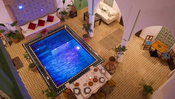 A model of a room with a pool, a sofa, a table with chairs, and various plants. - Riad Ocallaghan (Marrakech)