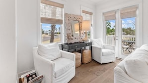 A bright living room with white furniture, large windows, and a view of the outdoors. - 30A! Sleeps 8 • 2 Pools • Golf Cart • Pet Friendly (Inlet Beach)