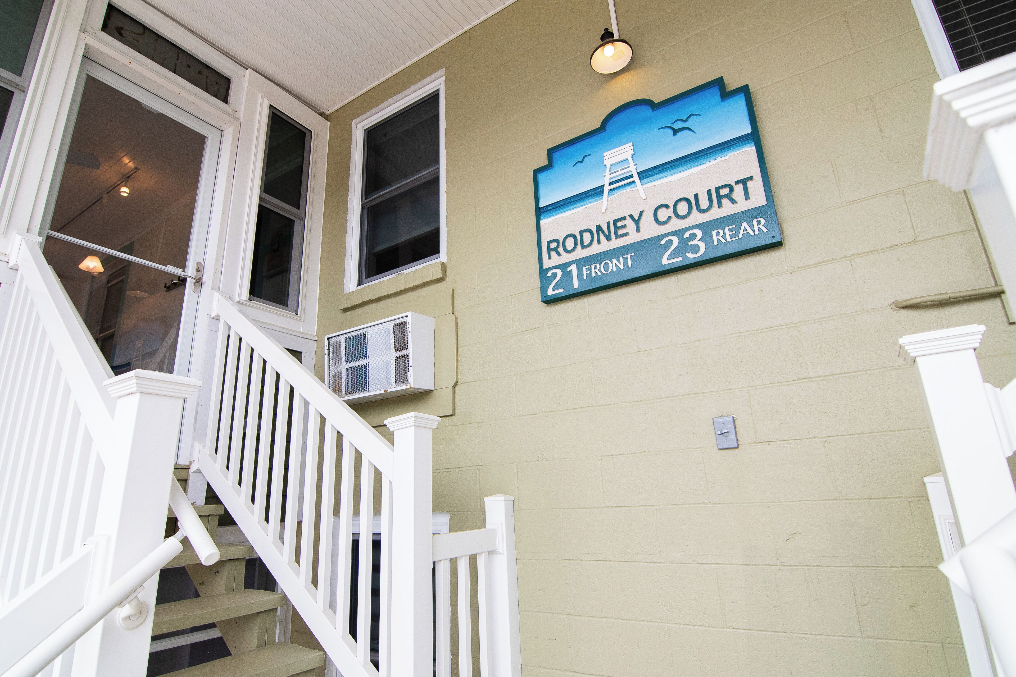 A building with a sign indicating "Rodney Court 21 Front 23 Rear".