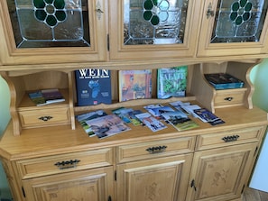 A wooden cabinet with glass doors, containing books and brochures. - Gemütliche Ferienwohnung Familienfreundlich! Mit 2 Hochstühle + 2 Kinderbetten (Meißen)
