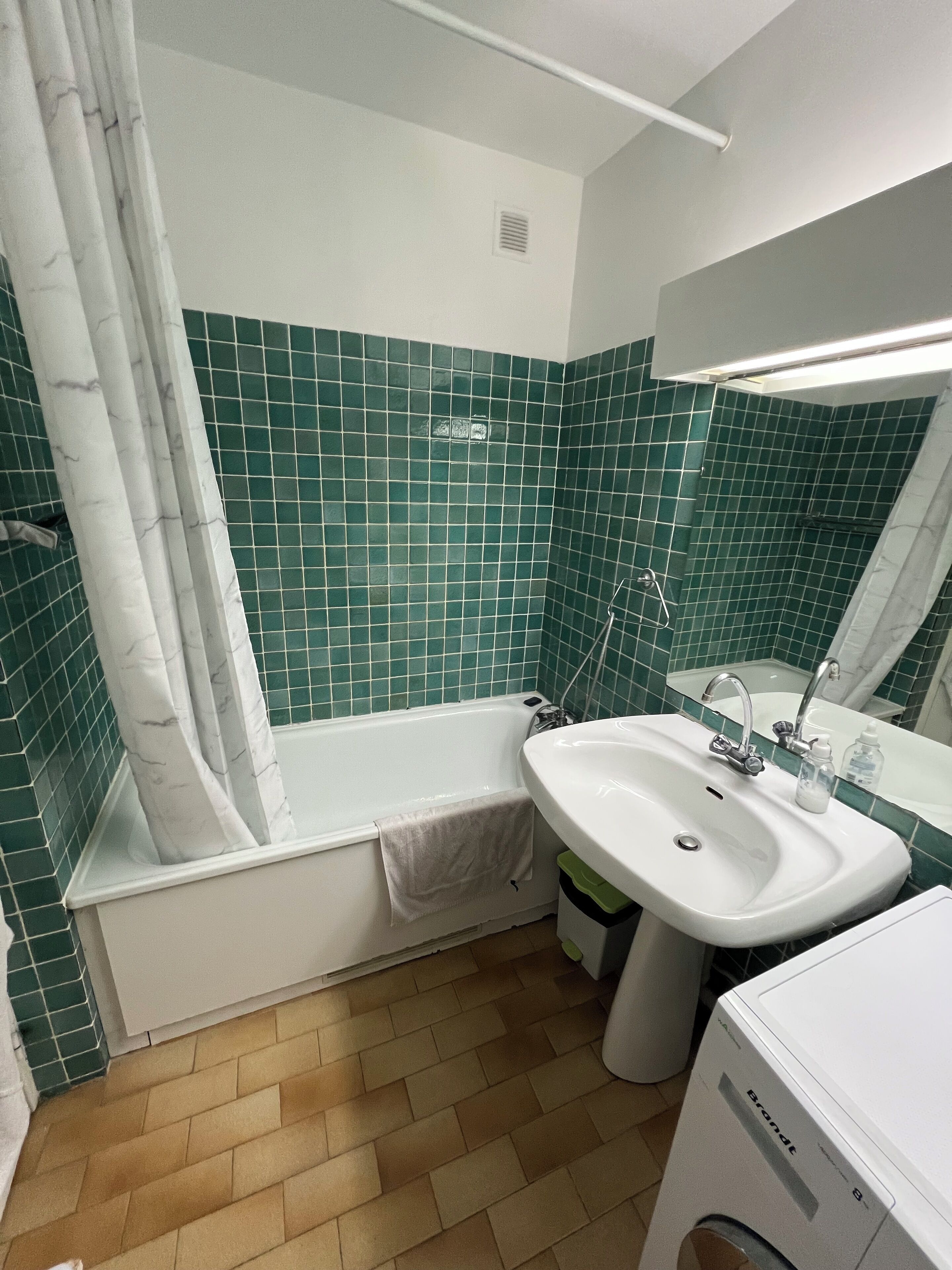 Un baño con bañera, lavamanos y espejo.