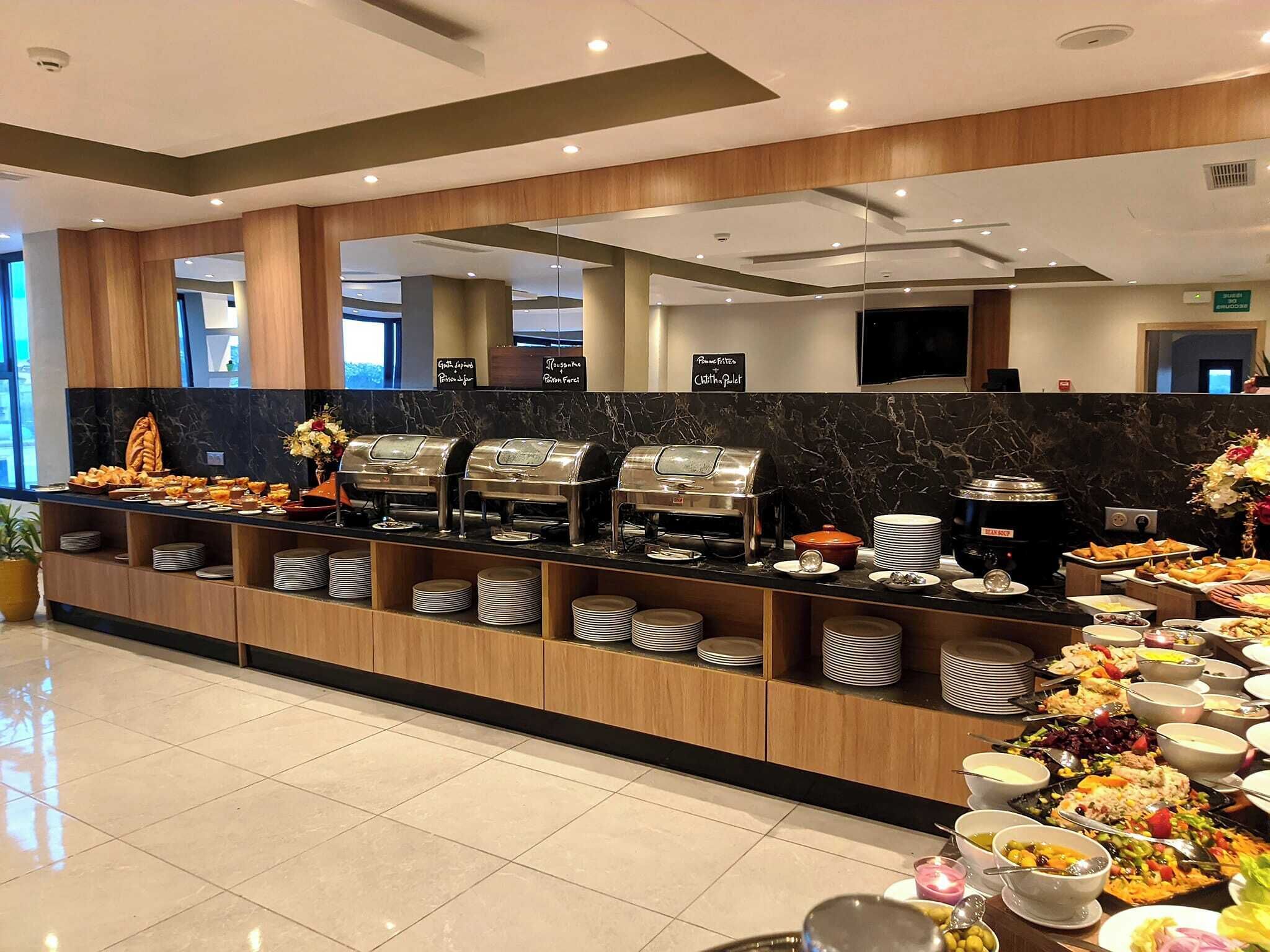 A buffet setup with various food stations, including a coffee station and a salad bar.