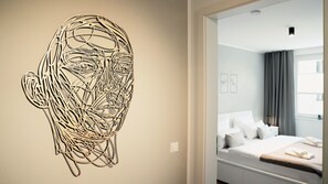 Ein Hotelzimmer mit Bett, Wandgemälde und einem fenster mit Vorhängen.