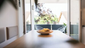 Un'area pranzo con tavolo, sedie e una ciotola di frutta.