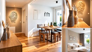 Un intérieur moderne avec une table à manger en bois, des chaises et une œuvre d’art accrochée au mur.