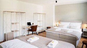 A hotel room with two beds, a desk, and a chair. - LaMiaCasa Tübingen | 2 Balconies | Private Parking | Central (Tübingen)