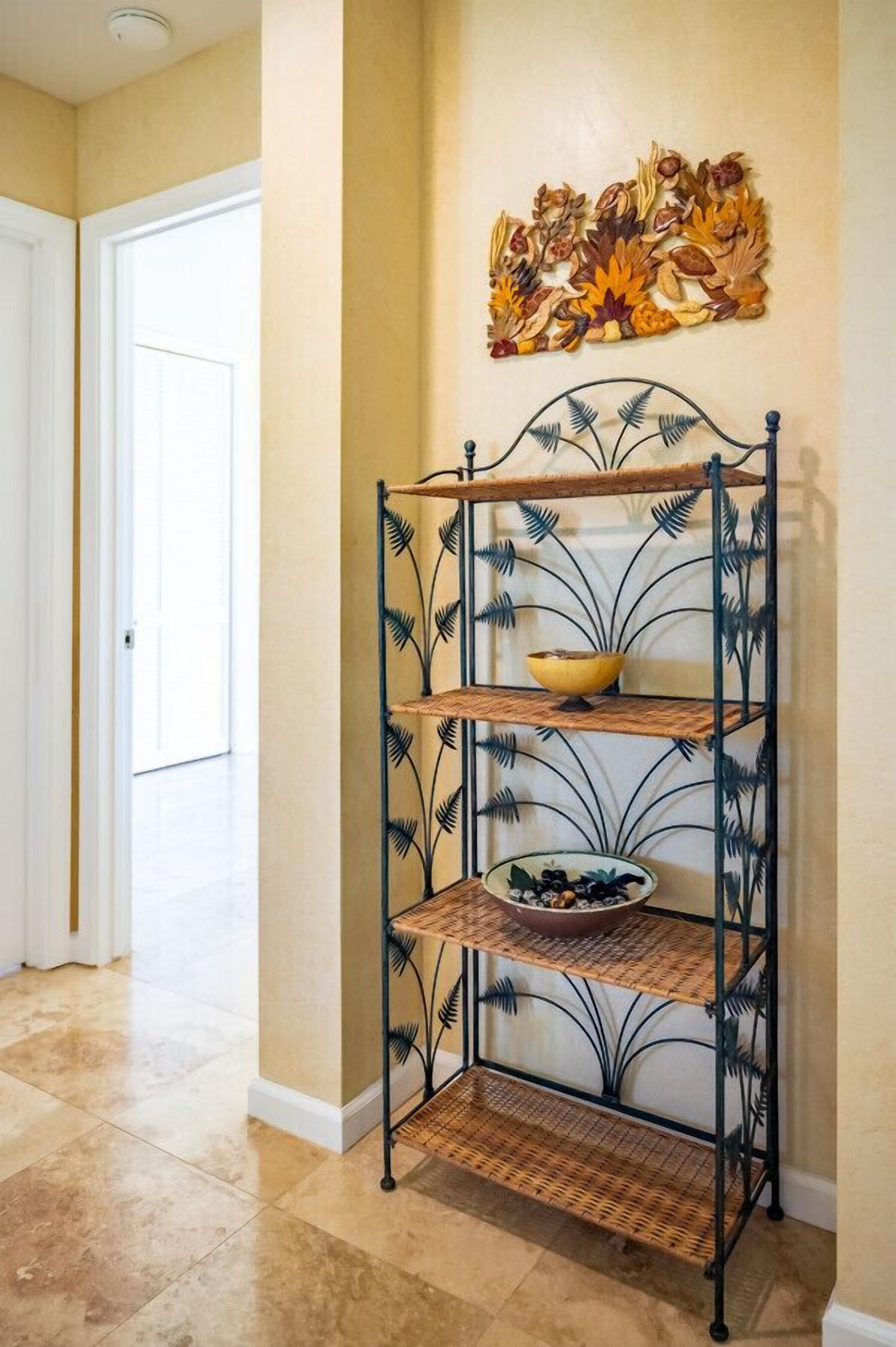 A metal shelf unit with three shelves, a decorative wall piece above it, and a door in the background.