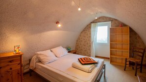 Ein Schlafzimmer mit Etagenbett, einem Holzkleiderschrank, einem Bücherregal und einem Globus auf einem Nachttisch.