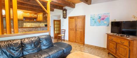 Ein gemütliches Wohnzimmer mit einer Ledersofa, Holzschränken, einem Fernseher und einer Karte an der Wand.