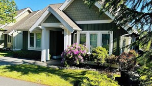 Une rangée de maisons unifamiliales avec des toits à deux versants, des porches à l’avant et une pelouse bien entretenue.