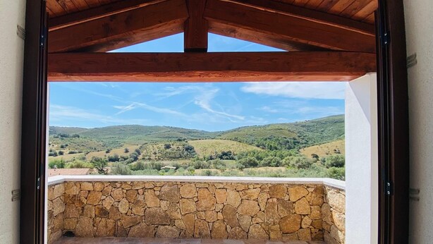 A stone wall with a view of green hills. - Newly built villas located in a quiet hamlet of San Teodoro.  (Schifoni)