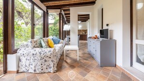 A modern living room with a sofa, a dining area, and a kitchen. - Fiorenza's charming beach house (Pula)