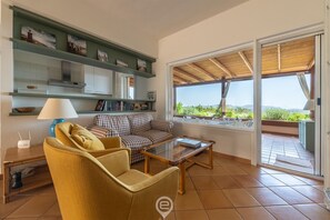 A living room with a sofa, coffee table, and shelves with books and decorative items. - Villa Erika (Pula)