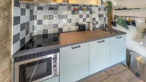 A modern kitchen with a checkered backsplash, stainless steel appliances, and light-colored cabinetry. - Cozy home in Noordscheschut with WiFi (Noordscheschut)