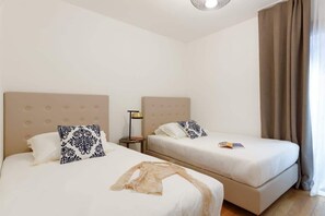 Two twin beds with headboards, a bedside lamp, and a window with curtains. - Alba sul mare - Portopiccolo Apartments (Duino-Aurisina)