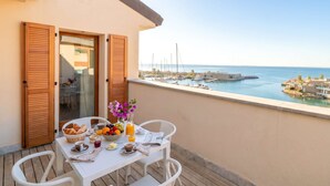 Ein Balkon mit Frühstückstisch mit Blick auf eine Marina und Boote.