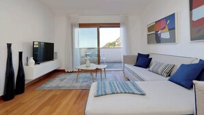 A modern living room with a sofa, TV, and a balcony view.