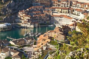 A coastal town with buildings, a marina, and boats. - La tempesta perfetta - Portopiccolo Apartments (Duino-Aurisina)