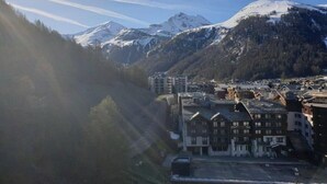 A mountainous town with snow-capped peaks, a mix of traditional and modern buildings, and a clear sky. - L'iseran - VAL D'isere (VAL D'ISERE)