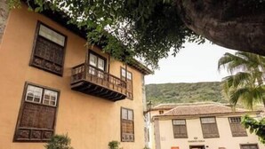 A building with a balcony, a door, and a window. - Near the Drago in Icod (Icod de los Vinos)