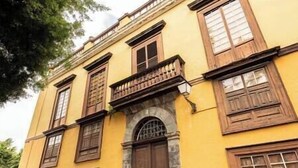 A yellow building with multiple windows and a central entrance. - Near the Drago in Icod (Icod de los Vinos)