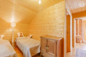 A wooden cabin room with two beds, a wooden cabinet, and a lamp. - Chez Cathy - Saint Remy DE Maurienne (SAINT REMY DE MAURIENNE)