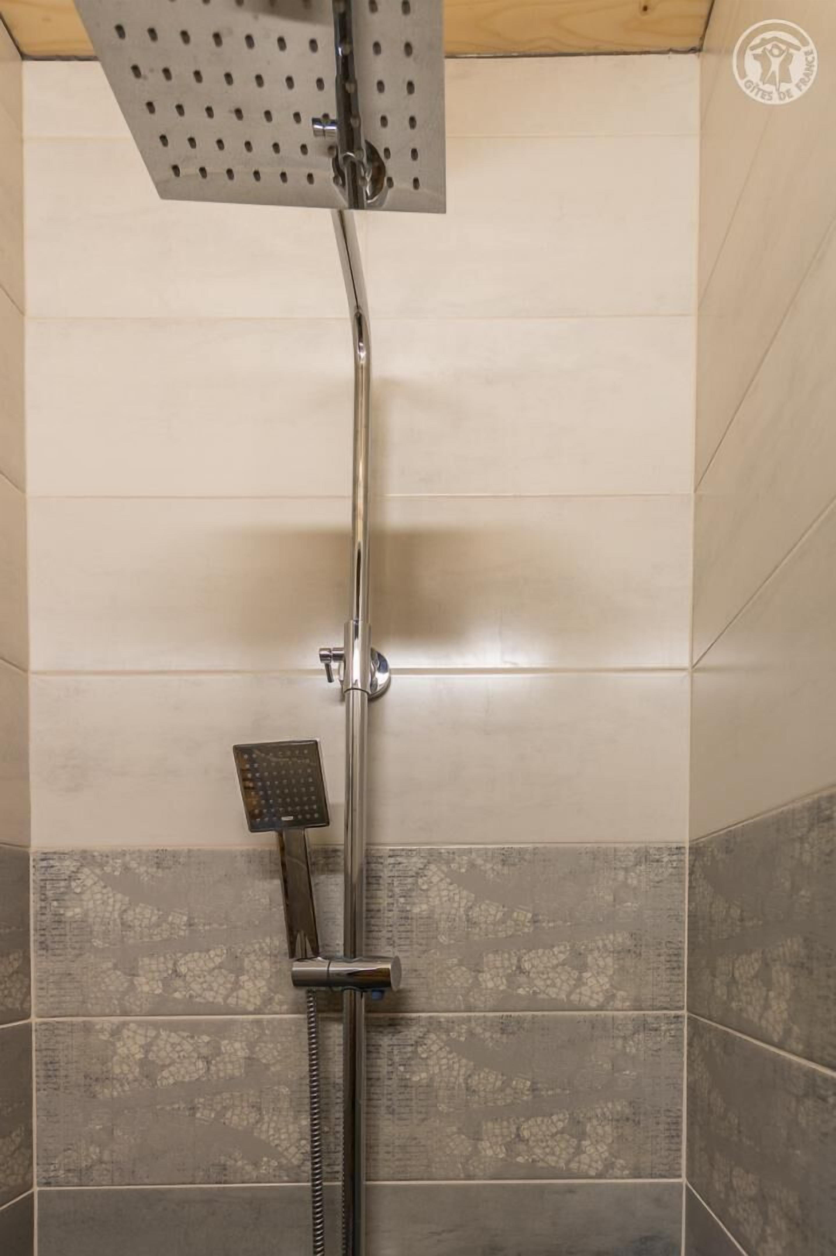 Eine Dusche mit Handbrause und fest installierter Duschkopf.