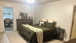 A bedroom with a bed, dresser, nightstand, and a desk with a chair. - Cozy home in a peaceful country setting with stocked pond. Relax and unwind. (Bridgeport)