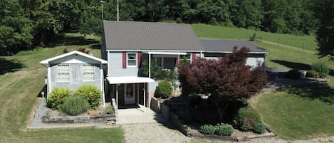 A two-story house with a front porch, a small attached garage, and a well-maintained lawn.