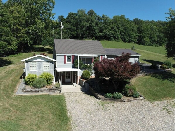 A two-story house with a front porch, a small attached garage, and a well-maintained lawn.