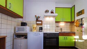 Una cocina compacta con lavadora, microondas y estufa.