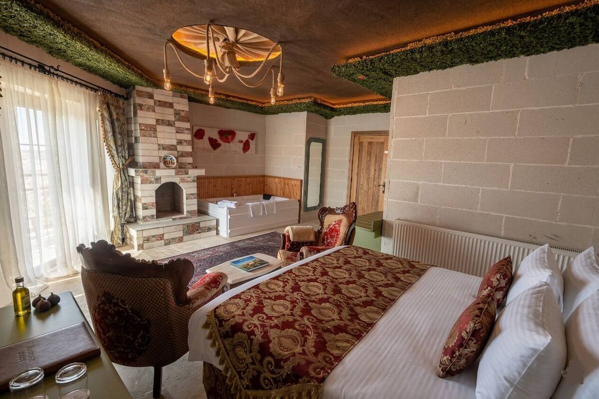 Ein Hotelzimmer mit Bett, Kamin, Spiegel und Stuhl.
