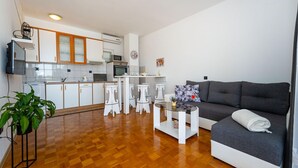 Een modern appartement met keuken, eethoek en woonkamer.
