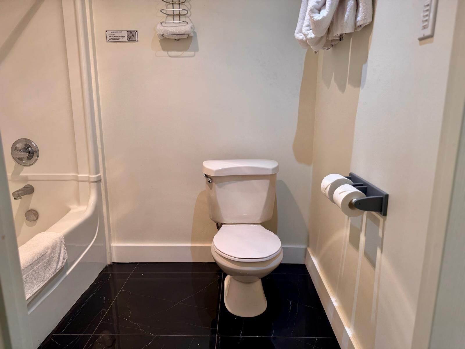 A bathroom with a toilet, a bathtub, and a towel rack.