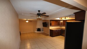 Una cocina con ventilador de techo, refrigerador y armarios de madera.