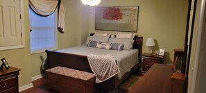 A bedroom with a bed, bedside tables, a nightstand, a bench, a window with curtains, and a painting on the wall. - Cozy & quiet 1 Bedroom apartment with pool table and big screen TV.  (Appomattox)