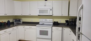 A kitchen with white cabinets, a microwave, a stove, a toaster, and a refrigerator. - Cozy & quiet 1 Bedroom apartment with pool table and big screen TV.  (Appomattox)