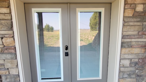 A double door with a stone wall and a welcome mat. - DISCOUNTS BOOK NOW! Beautiful 2 Bedroom Cabin with Great Views! (Island Park)