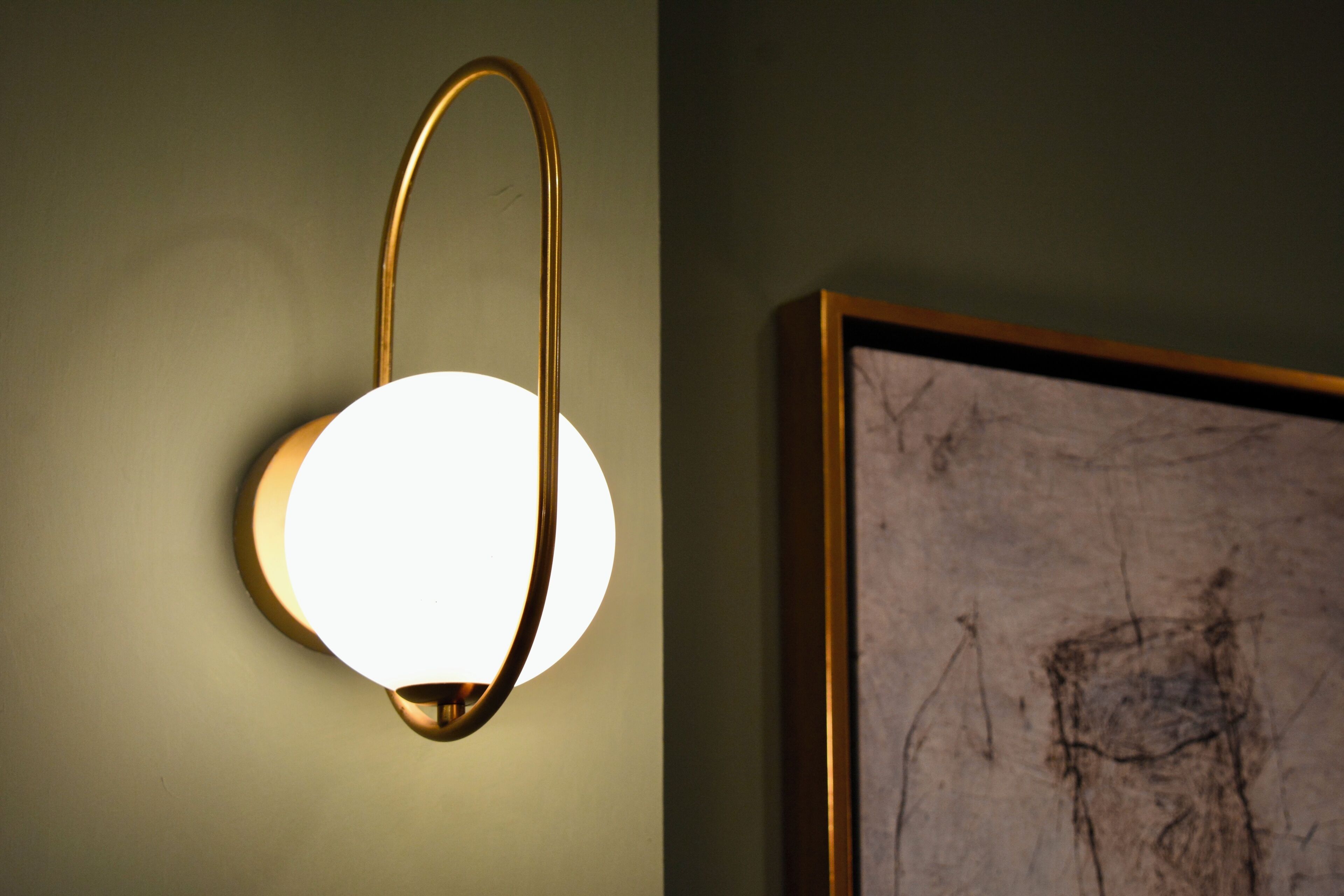 Un luminaire mural au design circulaire, doté d’un cadre de couleur dorée.