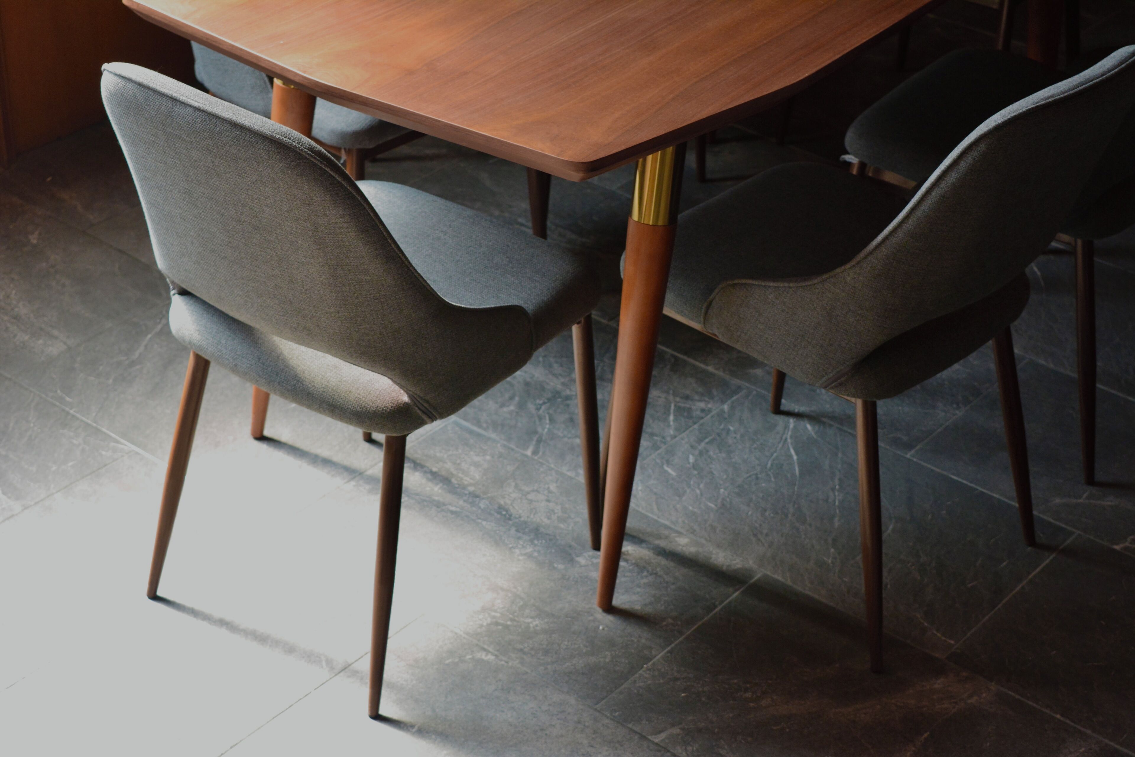 Un coin repas avec une table en bois et des chaises à revêtement gris.