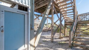 Eine Holzkonstruktion mit einer Treppe, die zu einem überdachten Bereich führt.