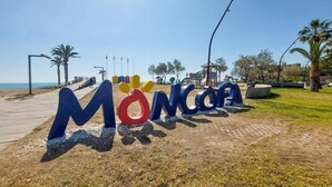 Un panneau placé au bord de la plage, sur lequel le mot « Móncora » est écrit en grandes lettres.