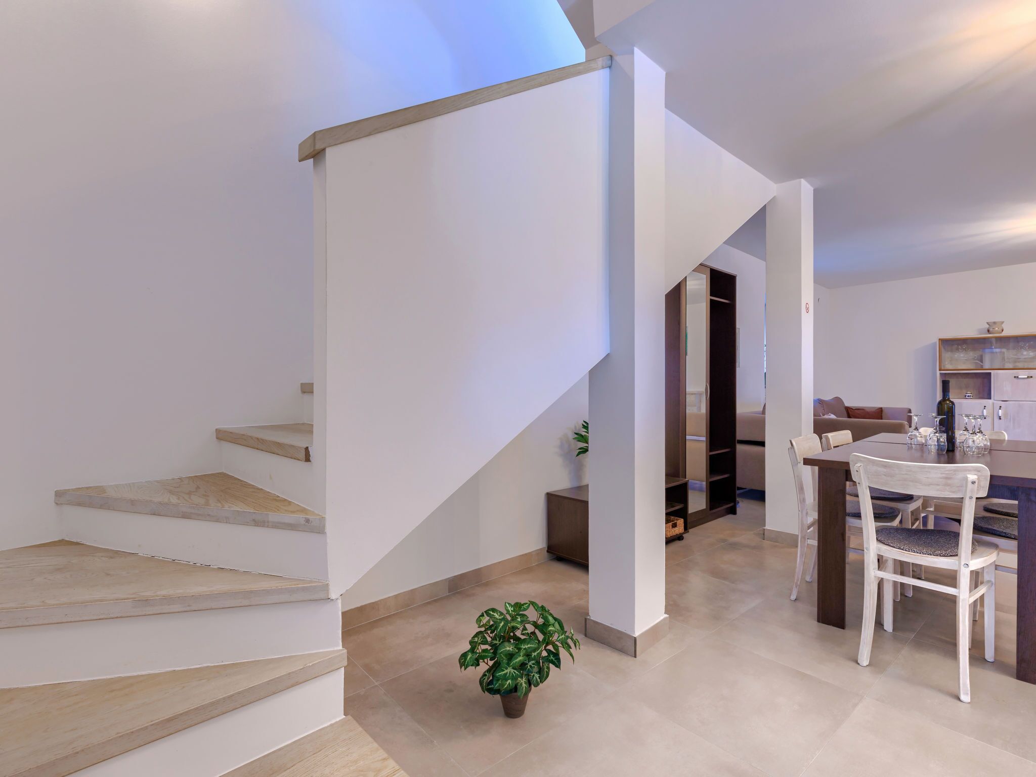 Ein modernes Interieur mit Treppe, Essbereich und Küche.