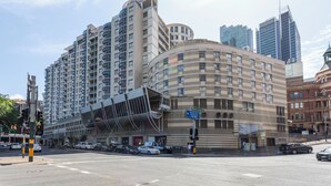 A modern hotel with a curved facade, multiple floors, and a prominent entrance. - GIA Sydney  (Sydney)