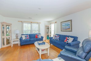 A living room with two blue sofas, a white coffee table, and a blue armchair.