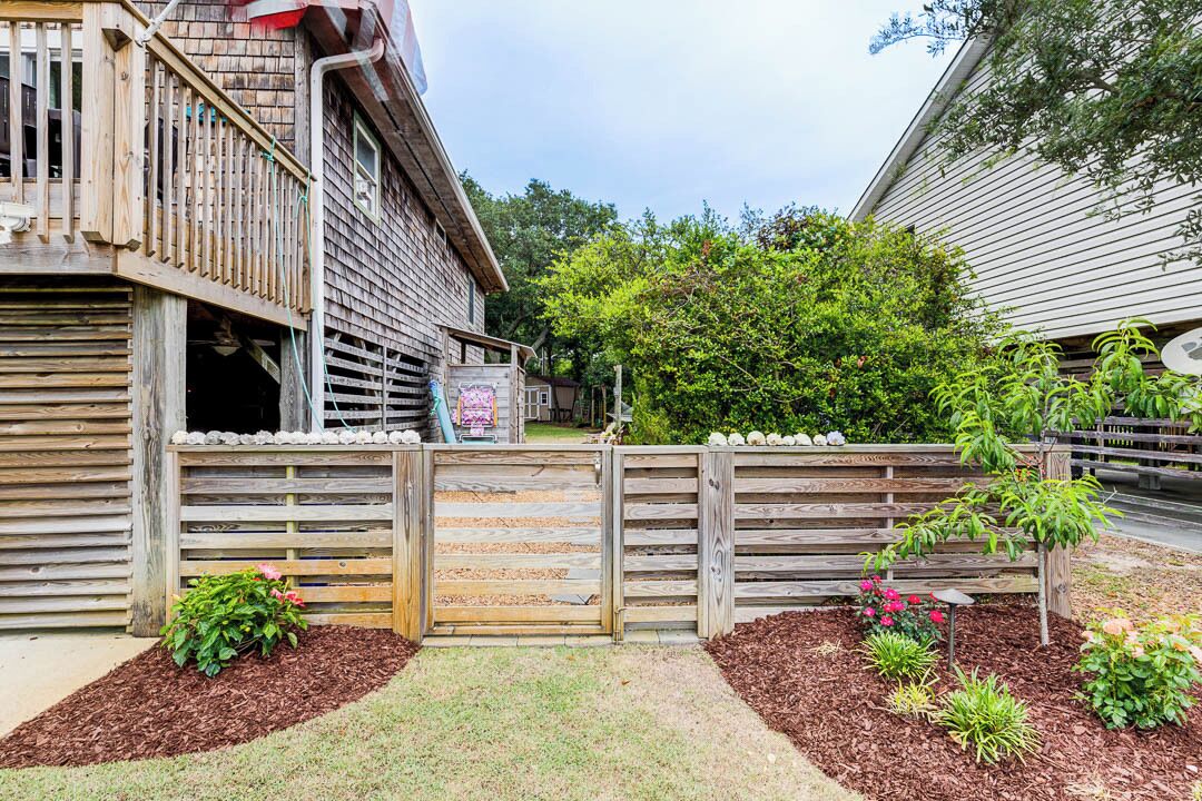 A wooden house with a porch and a gated entrance.